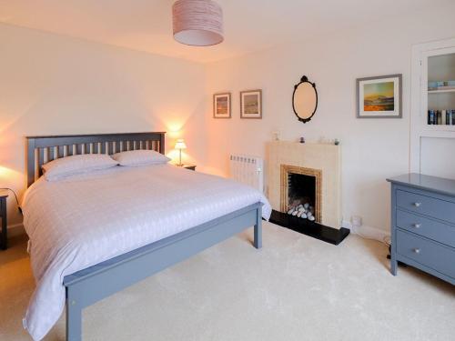 a bedroom with a bed and a fireplace at Fishers Cottage in Balintore