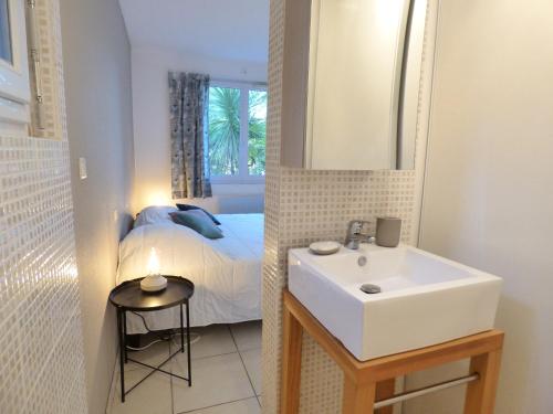 łazienka z umywalką i łóżkiem z lustrem w obiekcie *VILLA PALMA* 5 suites parentales, plage à 600 m, Vieux-Boucau w mieście Vieux-Boucau-les-Bains