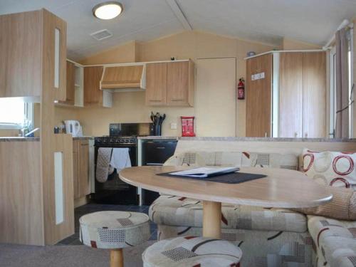 a kitchen with a table and chairs and a table and a kitchen at The Perrycroft at The Beeches Caravan Park in Gilcrux