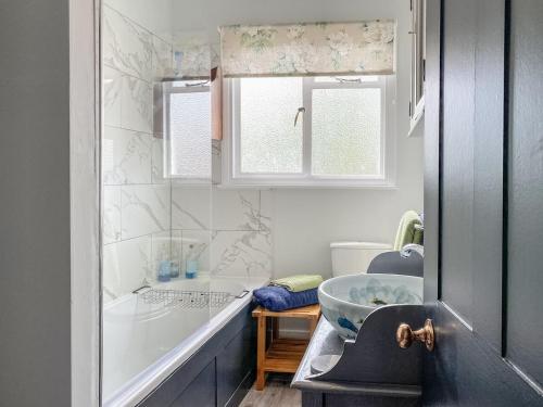 a bathroom with a tub and a sink at The Old Laundry Cottage in Hythe