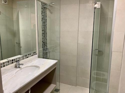 y baño con lavabo y ducha acristalada. en Depto a Estrenar 1 dormitorio con balcón en Córdoba