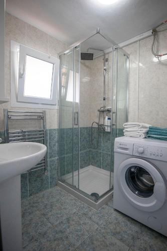a bathroom with a shower and a washing machine at Casa Corbeto 7 in Cómpeta