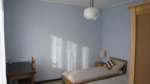 a bedroom with a bed and a table and a lamp at Il Piccione Viaggiatore in Banchette