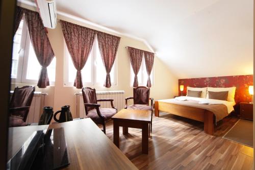 ein Hotelzimmer mit einem Bett und zwei Stühlen in der Unterkunft Rooms Konak Mikan in Belgrad