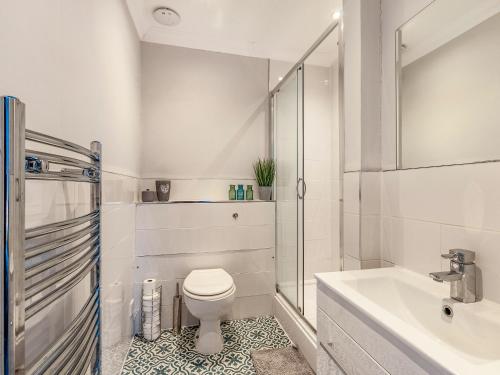 a white bathroom with a toilet and a sink at Walpole Heights Penthouse in Margate