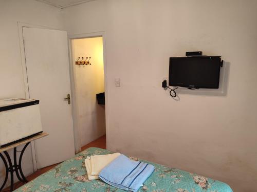 a room with a bed and a tv on the wall at Pousada L'étage in Búzios