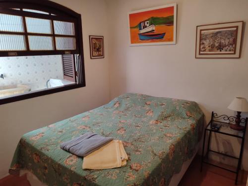a bedroom with a bed and a window at Pousada L'étage in Búzios