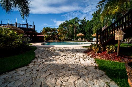a stone walkway leading to a swimming pool at Hacienda el Jibarito in San Sebastian