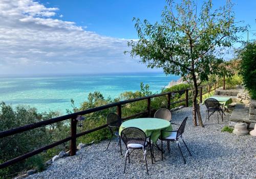 een tafel en stoelen met de oceaan op de achtergrond bij Villa Pietrafiore in Monterosso al Mare
