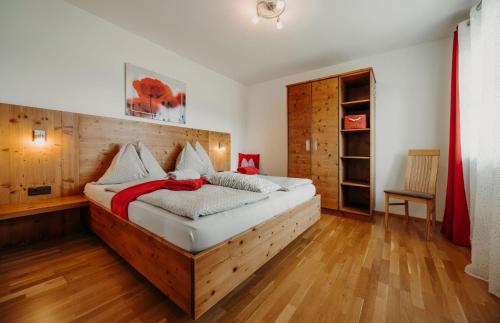 a bedroom with a large bed with a wooden headboard at Bauernhof Unterbichl in Flachau