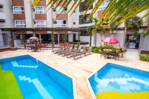 a swimming pool in front of a building at Boulevard Beach Canasvieiras Hotel in Florianópolis