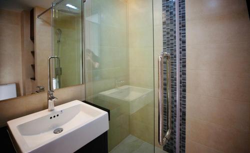 a bathroom with a sink and a glass shower at Mae Phim Escape Beachfront Apartments in Mae Pim