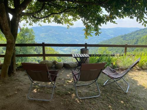 two chairs and a table with a view of mountains at Agriturismo La Collina degli Scoiattoli in Cravanzana