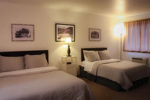 une chambre d'hôtel avec deux lits et une lampe dans l'établissement Mountain Creek Tavern, 