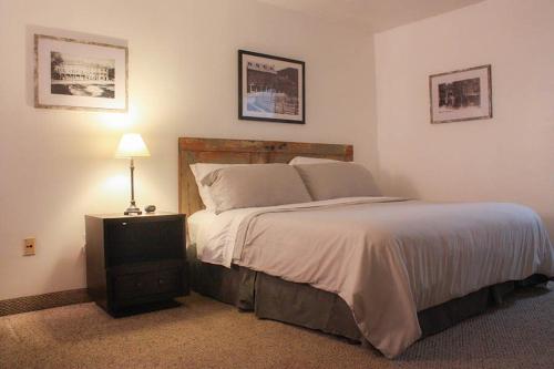 - une chambre avec un grand lit et une table de nuit dans l'établissement Mountain Creek Tavern, 