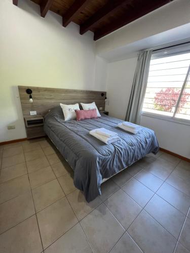 1 dormitorio con 1 cama grande y 2 almohadas en Hermoso duplex con estacionamiento en Guaymallén