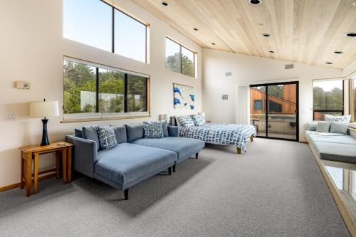 a living room with two blue couches and windows at The Indigo in Sea Ranch
