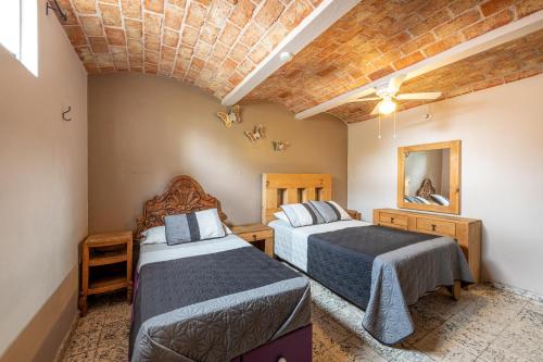 a bedroom with two beds in a room at Meson del Conde in San Miguel de Allende