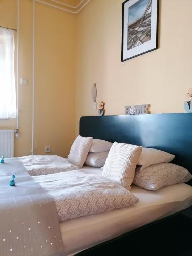 a bedroom with two beds with white blankets and pillows at Bianco in Sopron