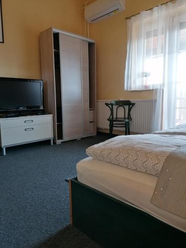 a bedroom with a bed and a flat screen tv at Bianco in Sopron