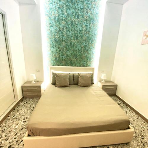een slaapkamer met een groot bed met 2 nachtkastjes bij Suite Pompeii in Pompei