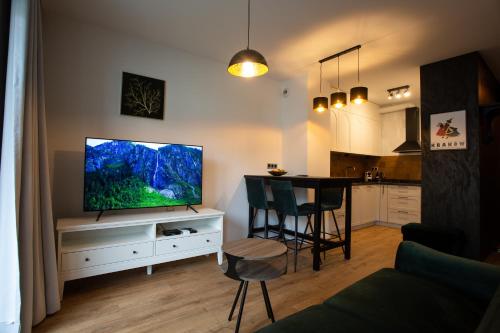una sala de estar con TV de pantalla plana en un armario blanco en Sunny Apartment Lwowska 10 en Cracovia