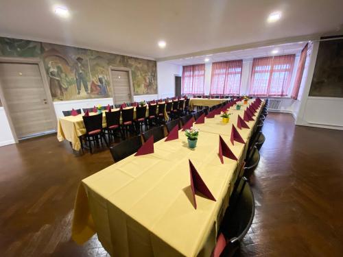 Hotel da Luca في Herzogenbuchsee: غرفة كبيرة مع طاولات وكراسي بعرصي حمراء