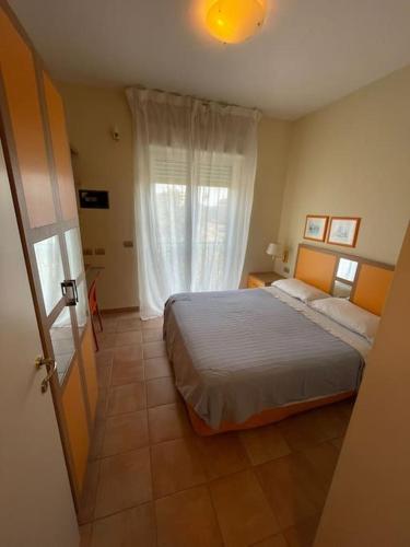 a bedroom with a large bed and a window at Tristan casa vacanze a Roma in Casal Palocco