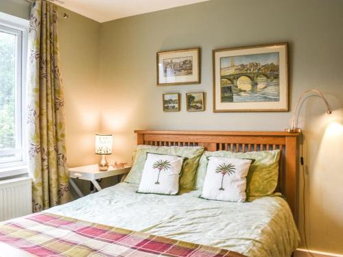 una camera con un letto con due cuscini di palma di Linstead House a Kendal