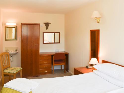 西德伯里的住宿－The Granary，一间卧室配有一张床、一张桌子和一个水槽