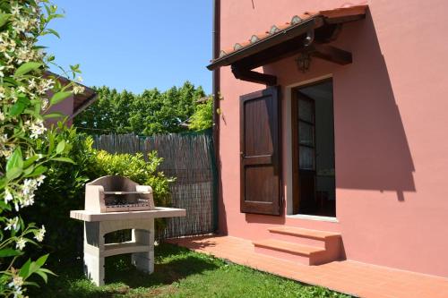 a small pink house with a grill in the yard at Terre di Melazzano - Le Case di Chiara in Greve in Chianti