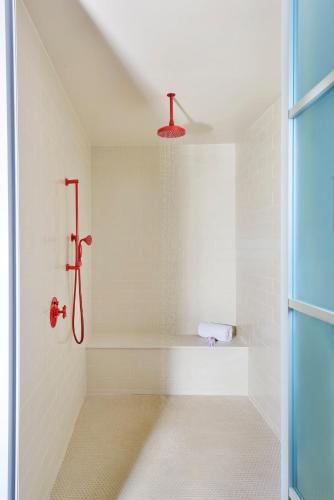 a bathroom with a shower with a red shower head at Virgin Hotels Dallas in Dallas