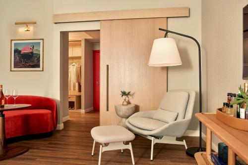 a living room with a chair and a red couch at Virgin Hotels Dallas in Dallas