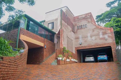 un edificio de ladrillo con un garaje con un coche en Palm View Apartment en Pretoria