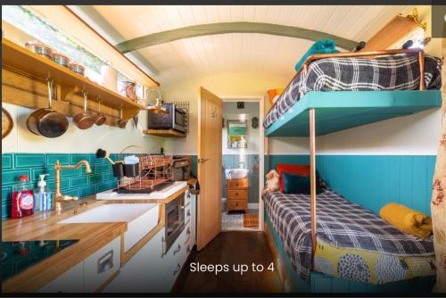 Shepherds Hut with Scandinavian Hot Tub and hydromassager في Sway: سرير بطابقين في مطبخ مع حوض