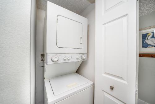 a white laundry room with a washer and dryer at Beach Condo Getaway in St. Augustine