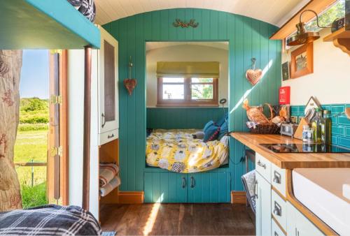 Habitación con cama en una pared verde en Shepherds Hut with Scandinavian Hot Tub and hydromassager en Sway