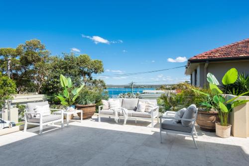patio con sedie bianche e vista sull'oceano di Huge Bayside Luxury Resort-Style Home with Pool a Burraneer