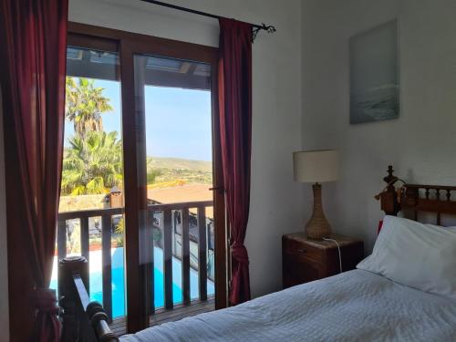 a bedroom with a bed and a balcony with a view at Finca Tropical in Arico Viejo