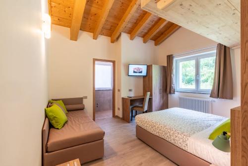 a bedroom with a bed and a chair and a desk at B & B Il Sottobosco in Val Masino