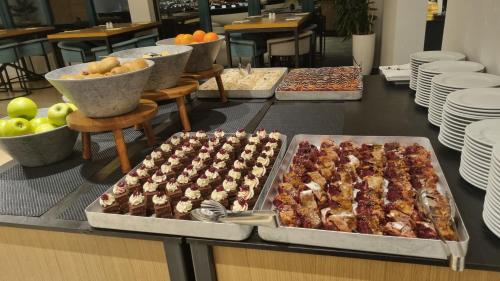 a buffet with several trays of food on a table at Kraljevi Konaci Olja in Zlatibor