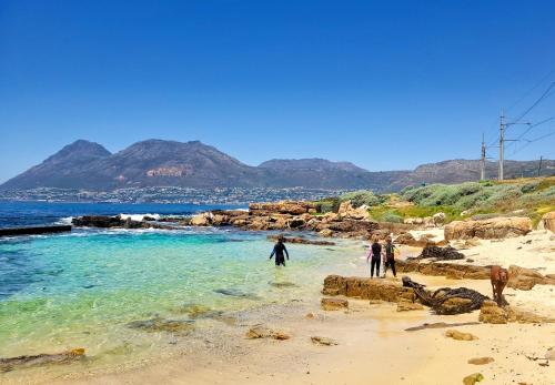 a group of people walking on the beach at Froggy Farm Self Catering in Simonʼs Town