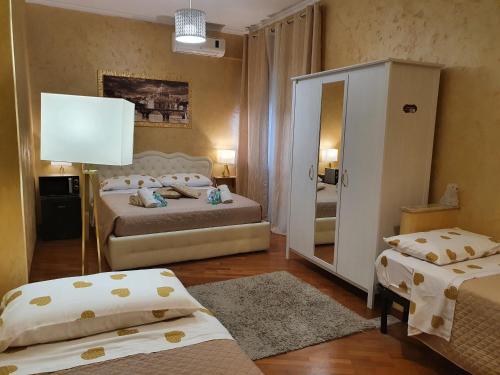 a bedroom with two beds and a mirror at San Pietro Chic in Rome