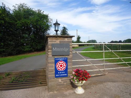 a sign on a gate with flowers in a vase at The Chaff House - farm stay apartment set within 135 acres in Bromyard