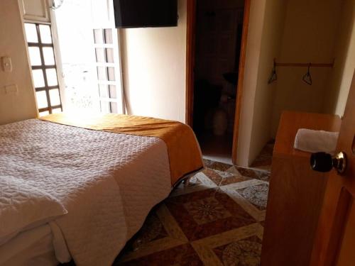 a bedroom with a bed and a window at CASA HOTEL GUADALUPE in Jesús María