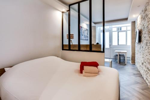 - une chambre avec un grand lit blanc et un oreiller rouge dans l'établissement Comfortable apartment - 1BR-4P - Palais Garnier, à Paris
