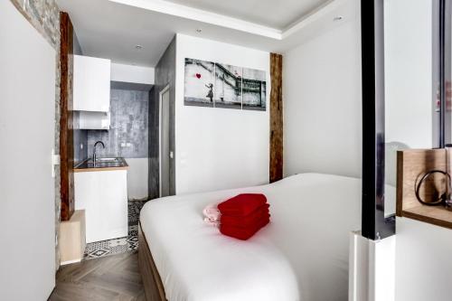 une chambre avec un lit avec un oreiller rouge dessus dans l'établissement Comfortable apartment - 1BR-4P - Palais Garnier, à Paris