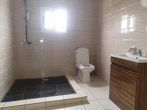 uma casa de banho com um chuveiro, um WC e um lavatório. em Beautiful Villa with Swimming Pool in Assinie em Mafia