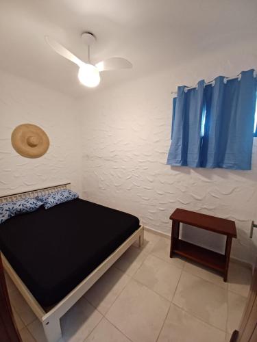 a small room with a bed and a table at Casa com Spa Praia do Pernambuco in Guarujá