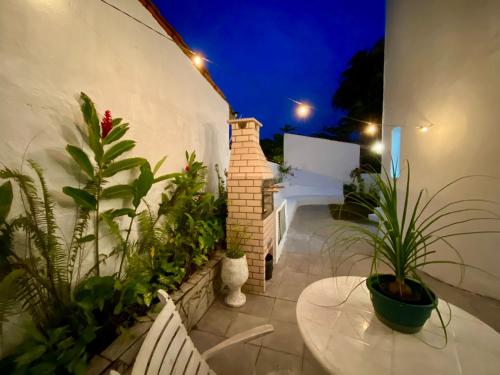 a patio with potted plants on a building at night at Casa com Spa Praia do Pernambuco in Guarujá